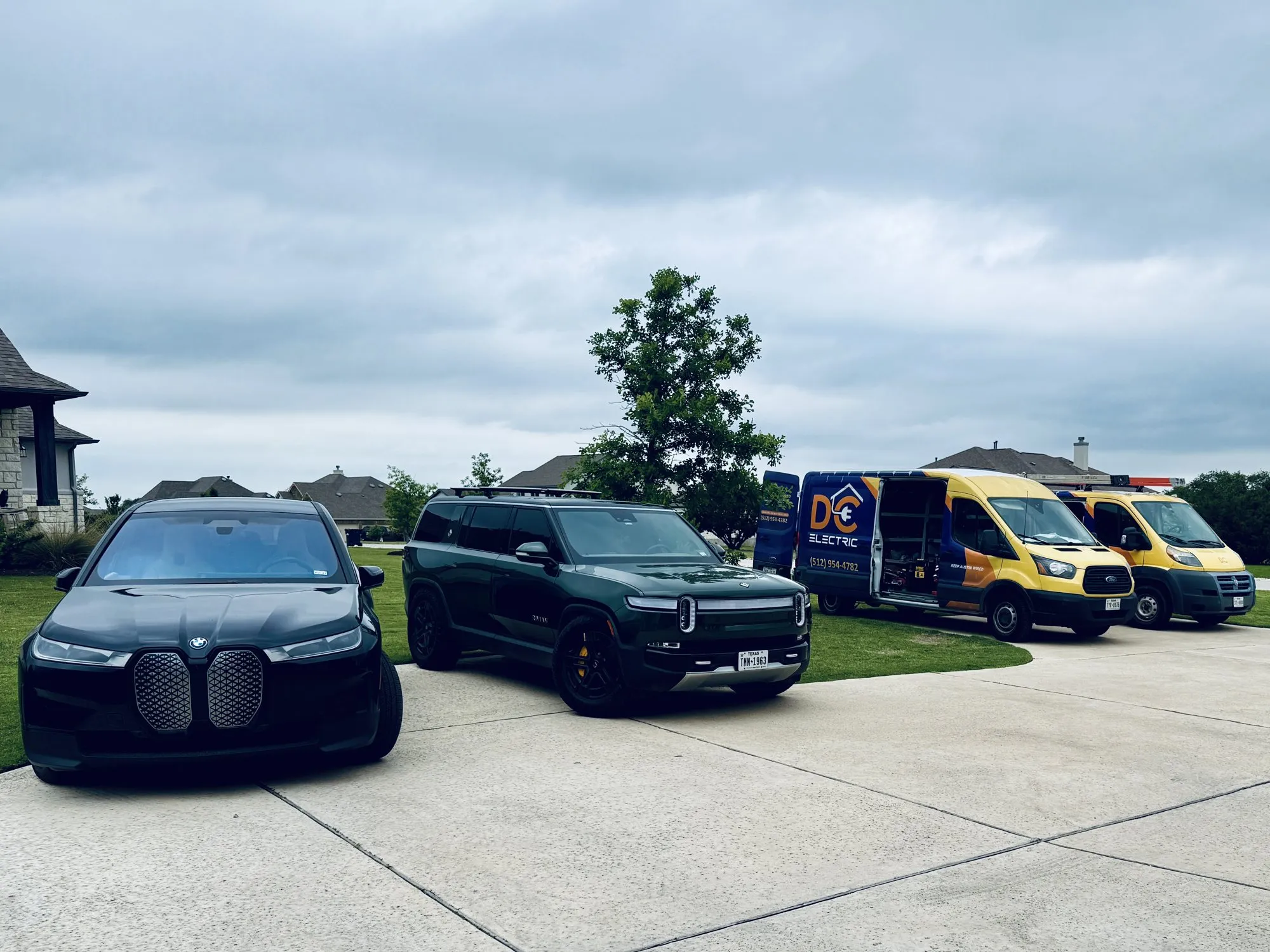An EV BMW and Rivian beside our trucks — licensed residential electrician in Austin TX (DC Electric)