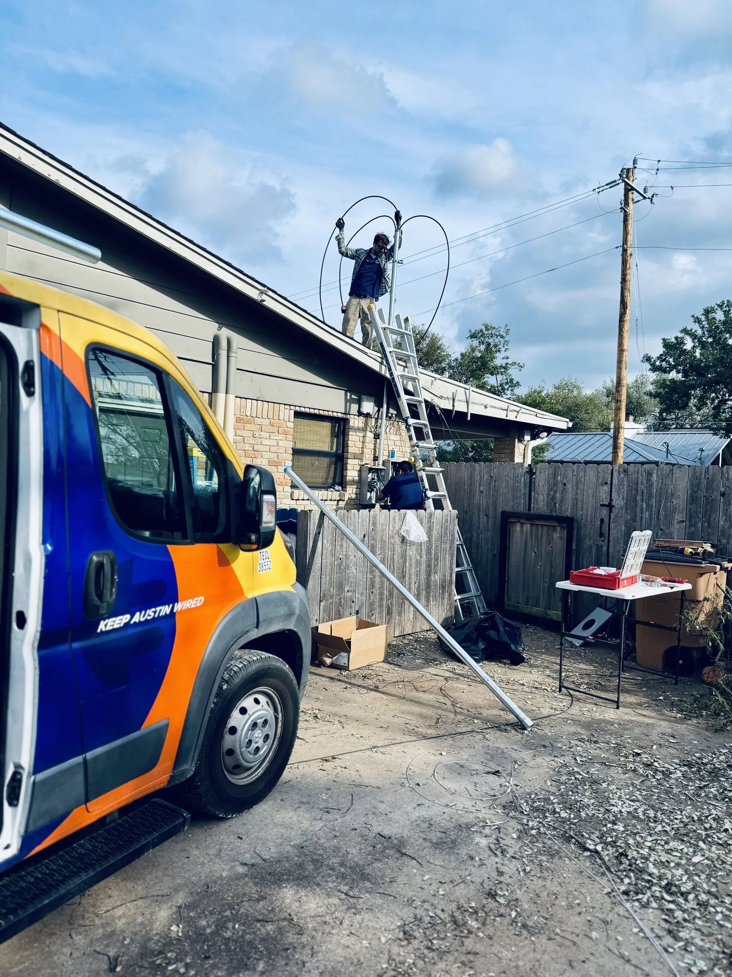 Reconnecting the service drop from the ladder — licensed residential electrician in Austin TX (DC Electric)
