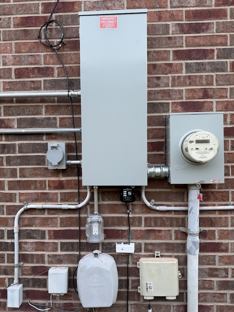 DC Electric panel replacement with exterior disconnect, meter and conduit on a brick wall